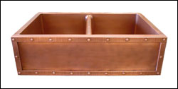 double basin copper farmhouse sink with hammered copper strapping and rivets on the apron front