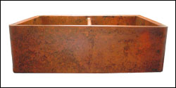 copper double basin farmhouse sink with custom orange patination on a smooth apron